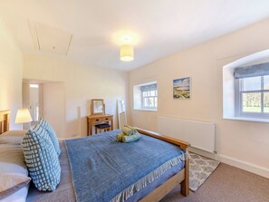 A bedroom with a bed, bedside table, lamp, and a window. - The Old Bakery - UK48319 (Berwick-Upon-Tweed)