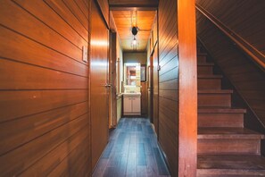 A wooden hallway with a staircase on the right.