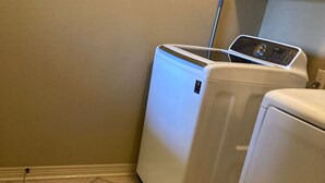 A laundry area with two white appliances, one dryer and one washer, on a tiled floor. - BestStays@King Bee. Large Groups OK.TVs in rooms
 (Tyler)