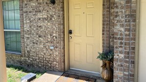 A brick house with a beige front door, a mailbox, and a potted plant by the door. - BestStays@King Bee. Large Groups OK.TVs in rooms
 (Tyler)