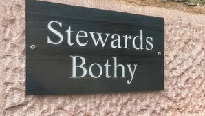 Un letrero negro con letras blancas que dice 'Stewards Bothy'.