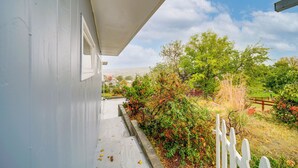 Un espace extérieur abrité, avec un chemin en béton menant à une clôture en bois.