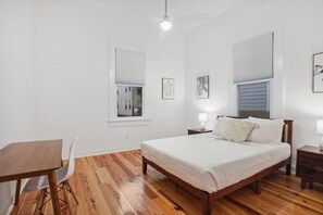 2 habitaciones, escritorio y tabla de planchar con plancha