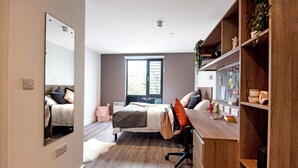 Una camera da letto moderna con un letto grande, una scrivania e un armadio.