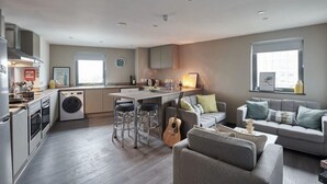 Un appartamento moderno con cucina, zona pranzo e soggiorno.