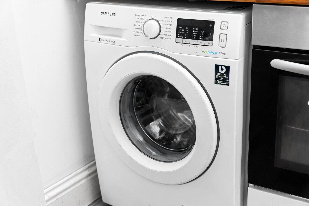 A Samsung digital inverter washing machine with a digital display, control panel, and a 8.0kg capacity label.