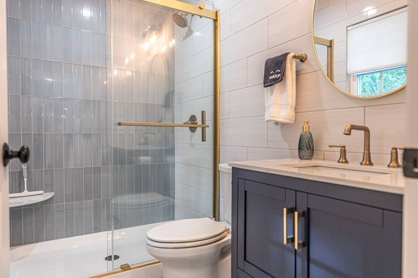 Une salle de bain moderne avec une douche à parois de verre, des toilettes, un meuble-lavabo et un miroir.