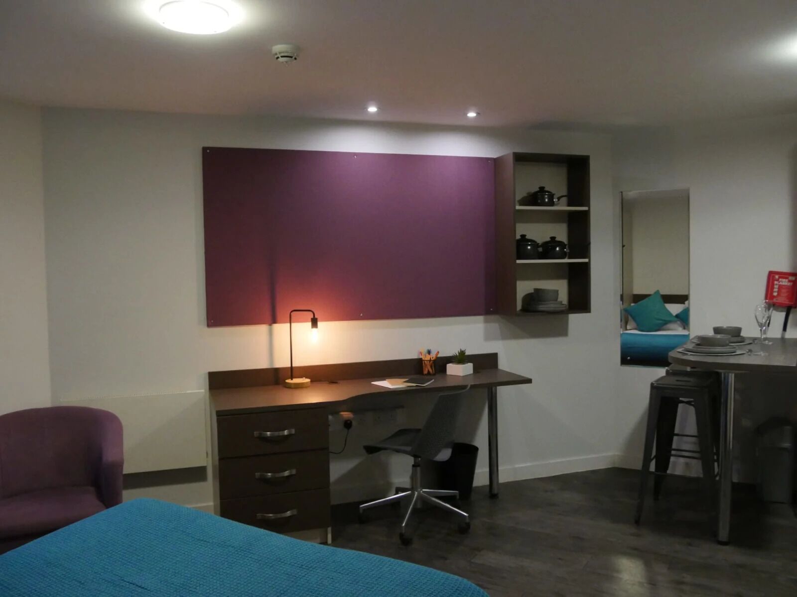 Un dormitorio moderno con escritorio, silla y cama.
