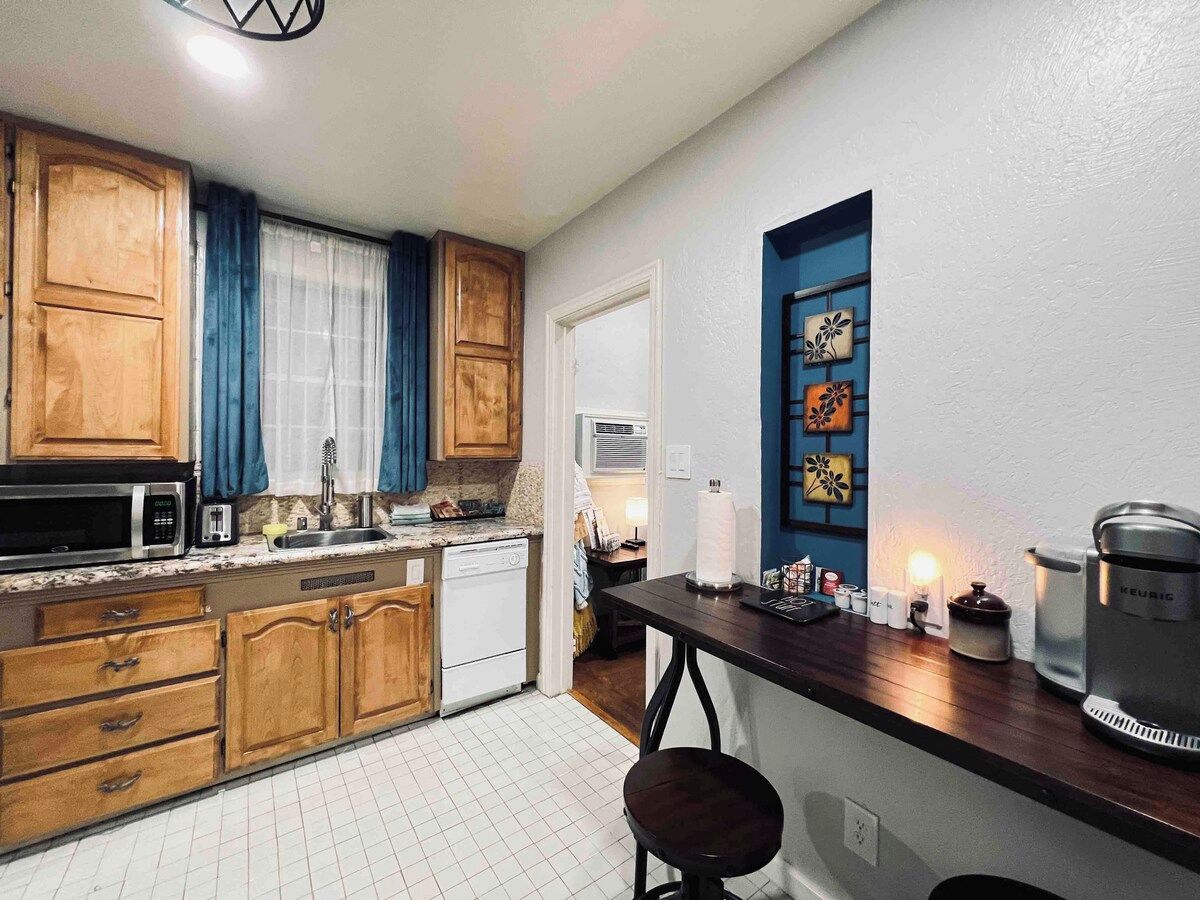 A kitchen with wooden cabinets, a microwave, a toaster, and a coffee maker.