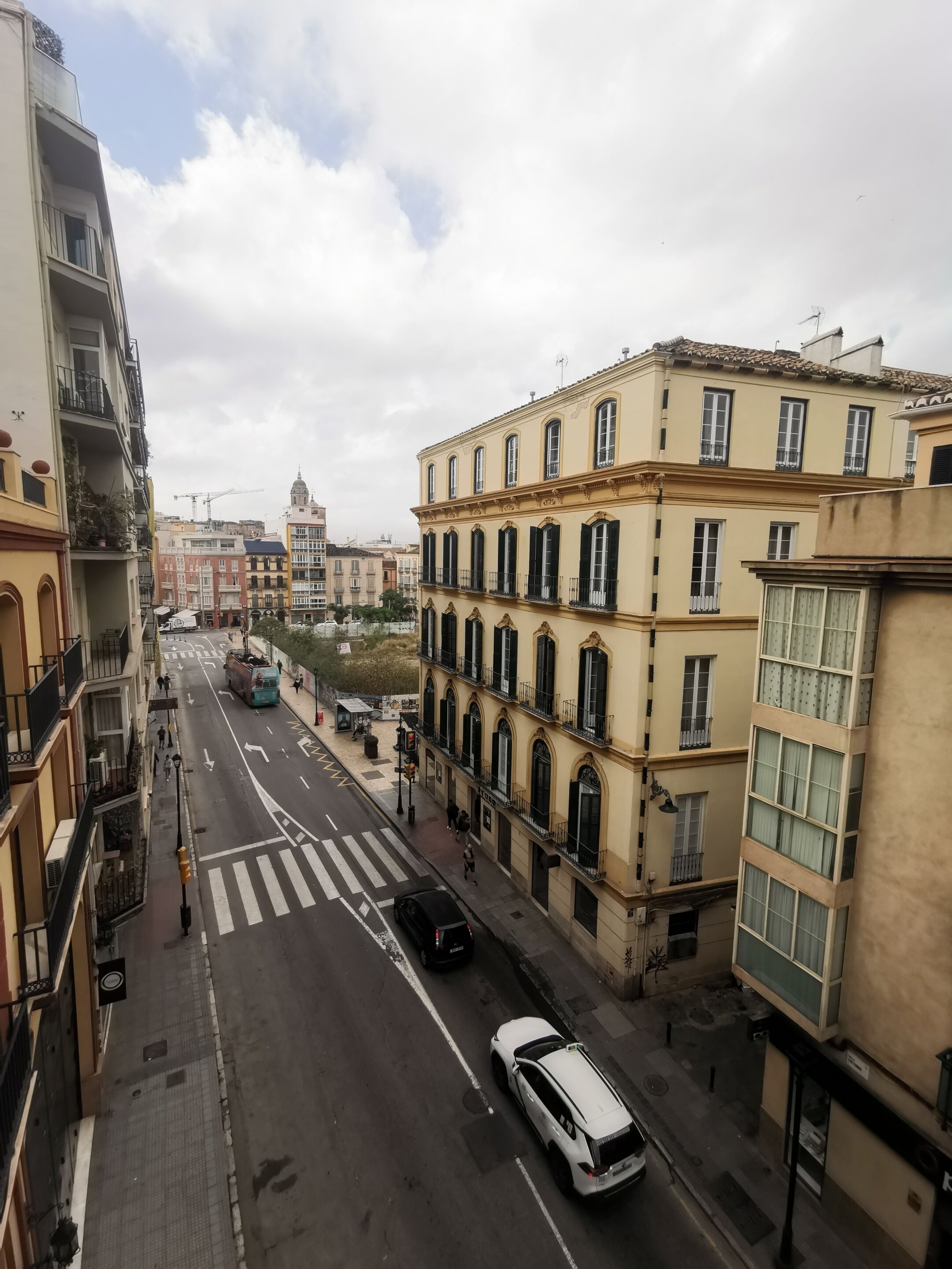 A street view with buildings, a crosswalk, and a bus.