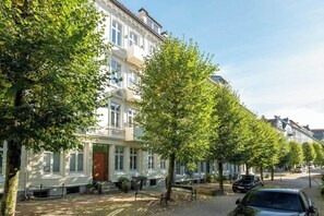 Traditional townhouses line a quiet, tree-lined street.