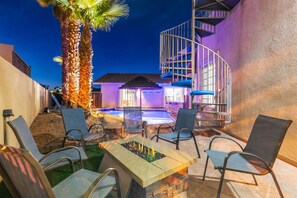 A patio area with outdoor seating, a fire pit, and a pool. - Havasu Mulberry - 5Min Walk To Beach, Pool, Spa, Game Room, FirePit (Lake Havasu City)