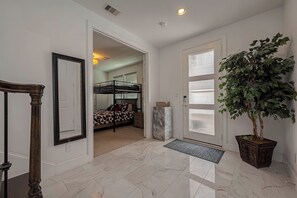 Enter a serene space with a polished floor, a potted plant, and a comfortable bed.