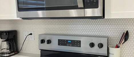 Een magnetron, een oven, een kookplaat, een vaatwasser