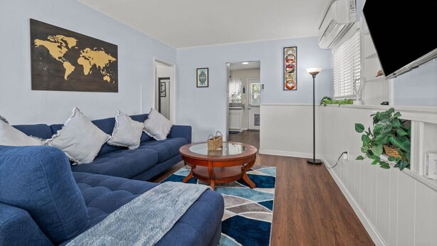 A living room with a blue sofa, a round coffee table, and a world map on the wall.