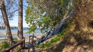 A wooden pathway leading to a beach with a bench and a railing. - Serenity on the Bay - Studio (Nanoose Bay)