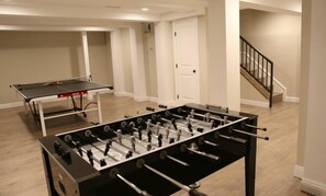 A room with a foosball table and a ping pong table. - Designer decorated 6 bedroom pool house (Santa Ana)