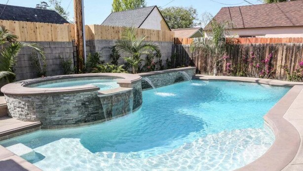 Une piscine dotée d’un jacuzzi et d’une cascade.