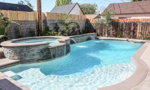 Une piscine dotée d’un jacuzzi et d’une cascade.