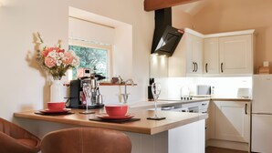 Una cocina moderna con una isla central, muebles blancos y un ventanal que proporciona luz natural.