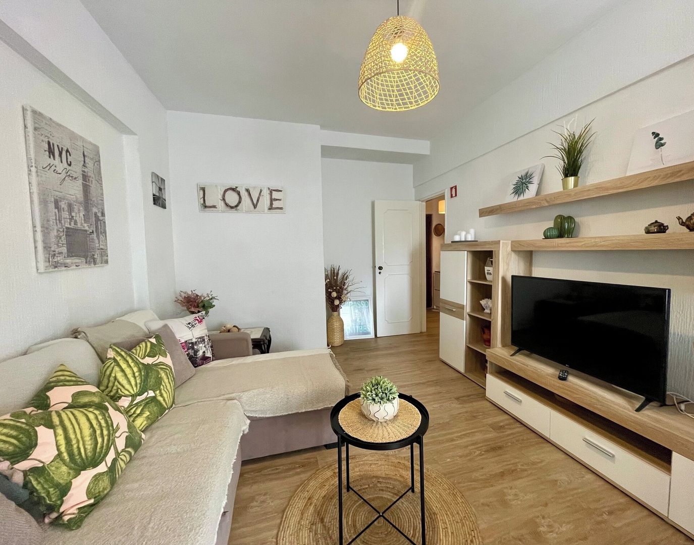 Una sala de estar moderna con un sofá, un televisor y elementos decorativos.