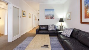 Una sala de estar con un sofá, una mesa de centro y un control remoto encima.