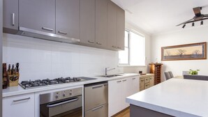 Una cocina moderna con electrodomésticos de acero inoxidable, armarios blancos y una isla grande.