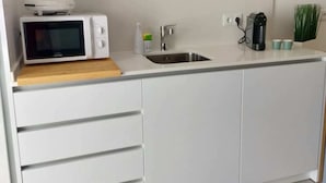 Une cuisine moderne équipée d’un four à micro-ondes, d’un évier et de tiroirs de rangement.