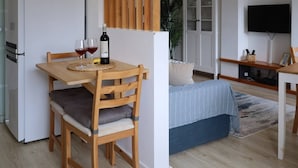 A modern living space with a dining area, a sofa, a TV, and a kitchen. - Mocho's  - Apartment (Mafra)