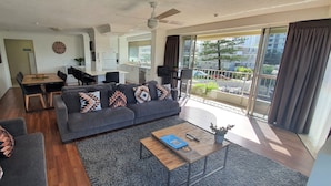 Ein modernes Wohnzimmer mit Sofa, Couchtisch und Essbereich.