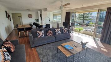 A modern living room with a sofa, coffee table, and dining area.