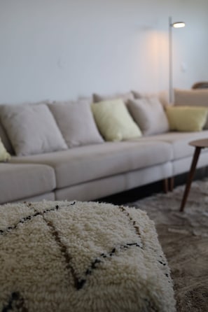 A living room with a sofa, a small round table, and a floor lamp.