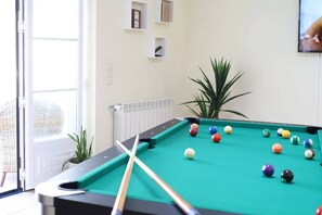 Un tavolo da biliardo con le bocce, una finestra e un termosifone.