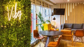 A modern interior with a green wall, a round table, and seating areas. - Student Only Buchanan View (Glasgow)