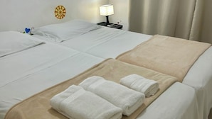 A hotel room with two beds, a bedside table with a lamp, and a wall decoration. - PEPÊ BEACH APARTMENT  (Barra da Tijuca Rio de Janeiro)