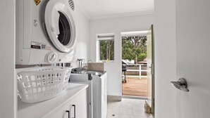 A laundry area with a washing machine, dryer, and a basket.