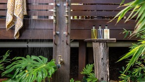 Une pergola en bois, avec une serviette suspendue d’un côté et une fontaine au centre.