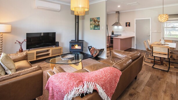 Ein modernes Wohnzimmer mit Sofa, Fernseher und Kamin.