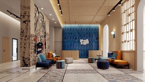 A modern lobby with a central seating area, a large blue wall with a clock, and patterned flooring.
