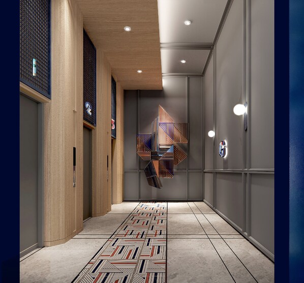 A modern hallway with a patterned floor, wooden paneling on one side, and a geometric light fixture on the ceiling. - Holiday Inn Express Bangkok Phayathai by IHG (Bangkok)