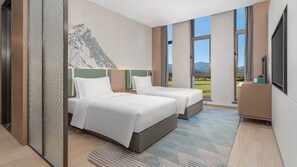 A modern hotel room with two beds, a large window with a mountain view, and a large artwork on the wall. - Holiday Inn Liaoyuan City Center by IHG (Liaoyuan)