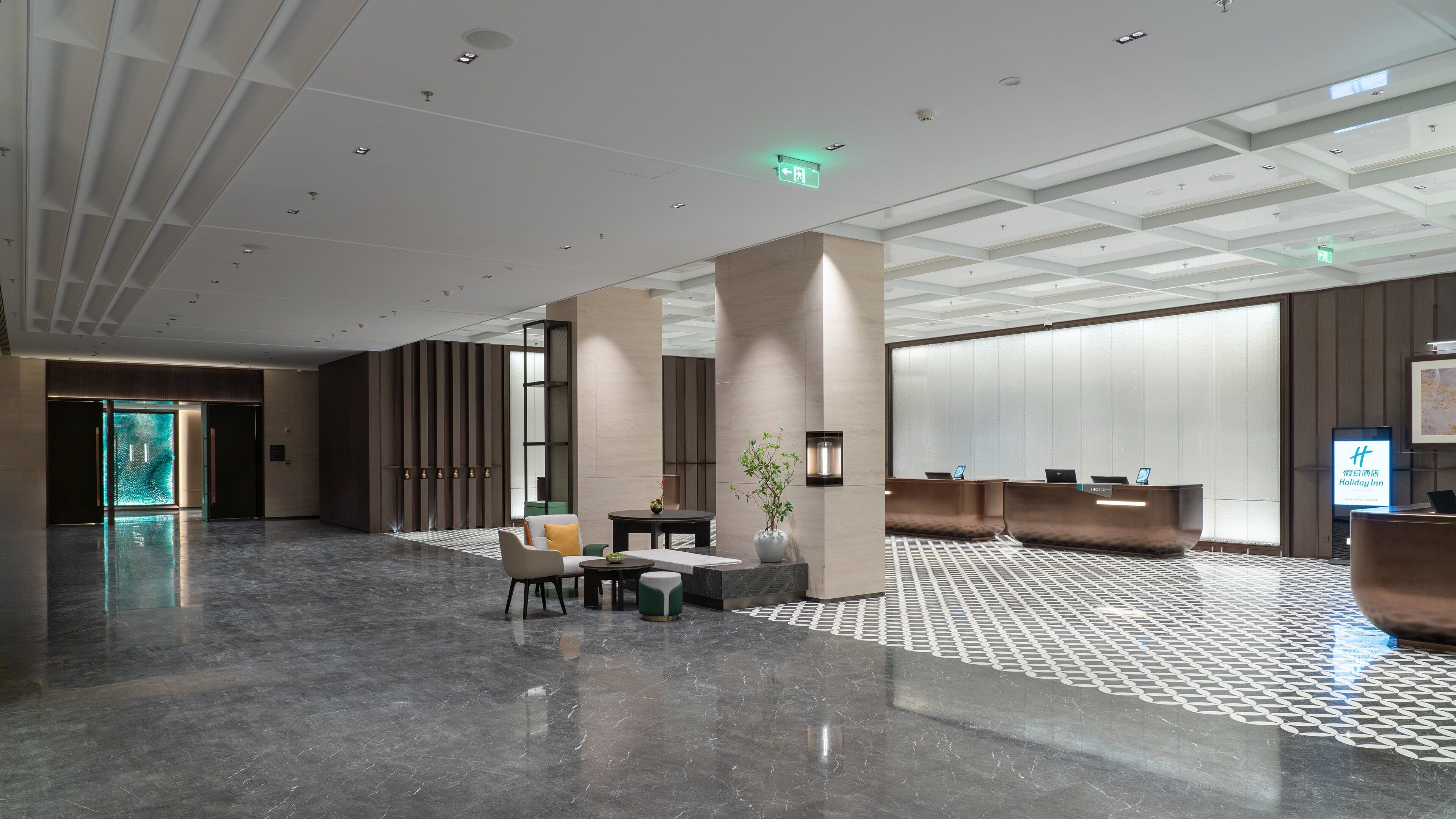 Un moderno vestíbulo de hotel con mostrador de recepción, zona de estar y una amplia pared de vidrio.