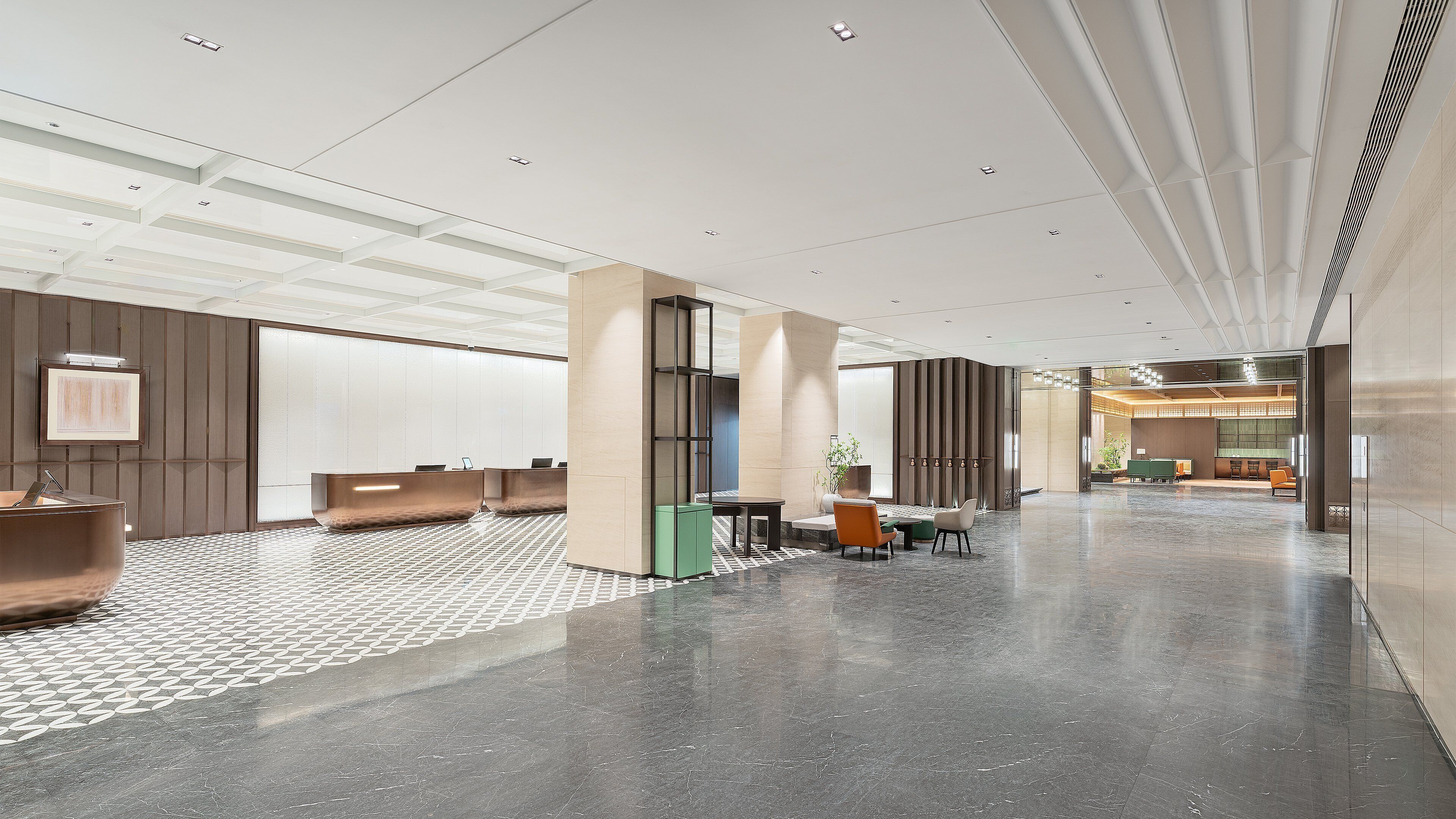 Un vestíbulo amplio con mostrador de recepción, zona de estar y diseño moderno.