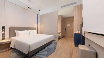 Una habitación de hotel moderna con una cama grande, un escritorio y una televisión.