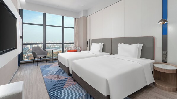 A hotel room with two beds, a TV, a chair, a small table, and a view of the city. - Holiday Inn Express Wuhan East Lake by IHG (Wuhan)