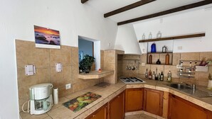 A kitchen with a gas stove, coffee maker, and various kitchen utensils.