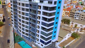 Un hotel de varios pisos con zona de piscina y vistas del barrio circundante.