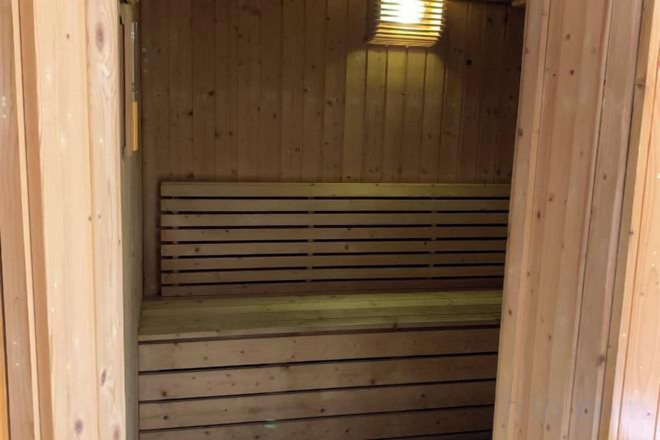 Een houten sauna met een bank en treden.