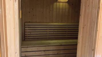 Een houten sauna met een bank en treden.