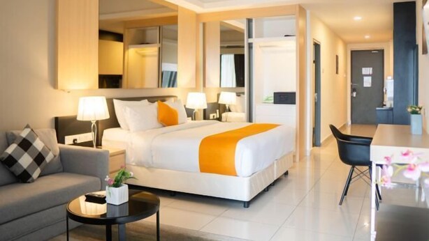 Une chambre d’hôtel moderne équipée d’un grand lit, d’un canapé, d’une table à manger et d’un bureau.